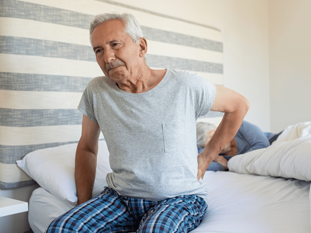 Elderly Man In Bed With Lower Back Pain