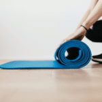 Woman Rolling Up A Pilates Mat