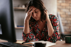 Woman Working In Office With A Painful Headache